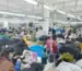 Factory worker stitching a two-tone varsity jacket body and sleeve
